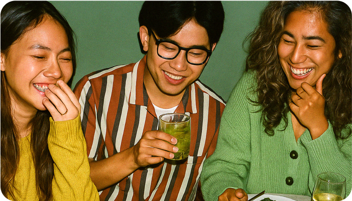 Friends smiling and writing in notebooks